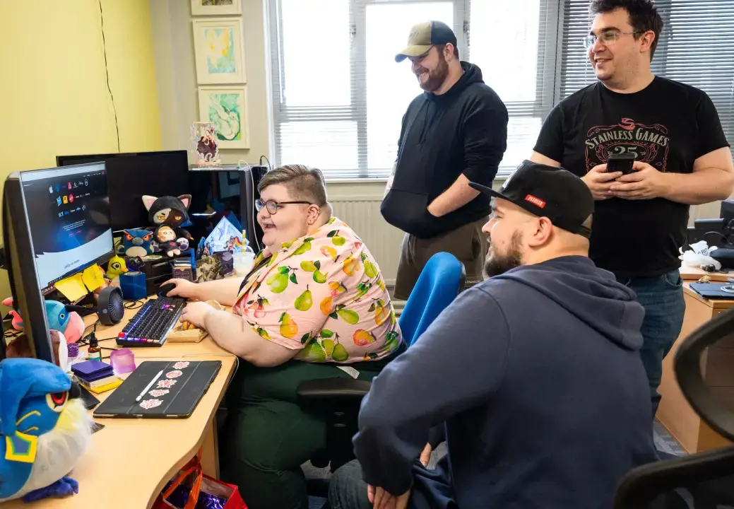 Photo of multiple Stainless Games team members all working on the same computer